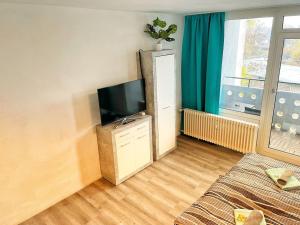 a living room with a flat screen tv on a dresser at Apartment nähe Flughafen DUS in Düsseldorf