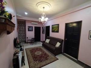 a living room with a couch and a chandelier at Comfort Home Rawang in Rawang