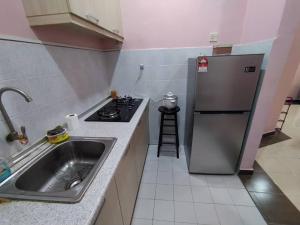 a small kitchen with a sink and a refrigerator at Comfort Home Rawang in Rawang