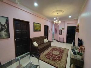 a living room with a couch and a chandelier at Comfort Home Rawang in Rawang