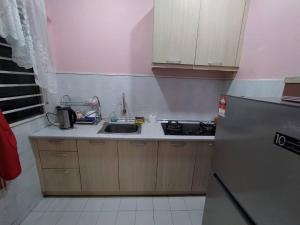 a small kitchen with a sink and a refrigerator at Comfort Home Rawang in Rawang