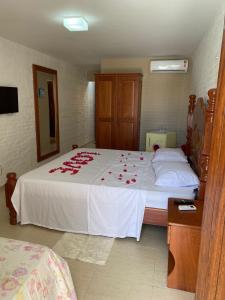 een slaapkamer met een bed met rozen erop bij Pousada Lua Vermelha in Caponga