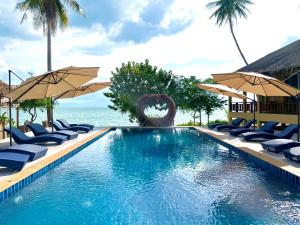 una piscina con sillas y sombrillas junto al océano en Absolute Beachfront Villas en Baan Tai