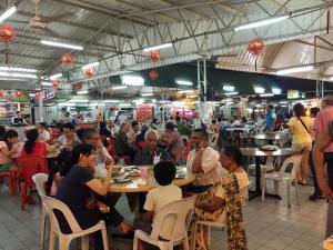 a group of people sitting at tables in a restaurant at Ardour Lodge "A" Wing in Tanjung Bungah