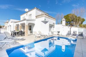 a villa with a swimming pool in front of a house at Piscina, mar y centro – Casa ideal para familias in Empuriabrava