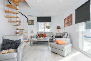 a living room with a couch and chairs and a tv at Empurialola - Casa todo confort, con piscina, cerca de la playa y centro - 131 in Empuriabrava
