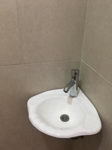 La salle de bains carrelée est pourvue d'un lavabo blanc. dans l'établissement Departamento frente al Mar Necochea, à Necochea