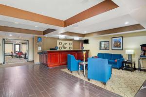 a hotel lobby with blue chairs and a bar at Comfort Inn & Suites in Griffin