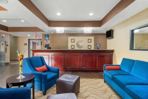 a living room with blue couches and a bar at Comfort Inn & Suites in Griffin