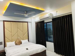 een slaapkamer met 2 bedden en een plafondventilator bij Hotel New City Light in Surat