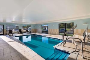 a pool in a hotel with blue water and windows at Comfort Suites Suffolk - Chesapeake in Suffolk