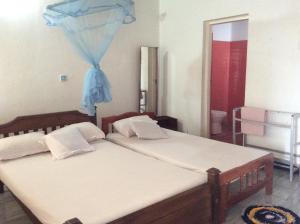 een slaapkamer met 2 bedden en een blauw net bij New Rest House Sea view Hotel in Negombo