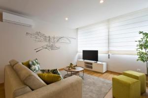 uma sala de estar com um sofá e uma televisão em APOSENTUS - Marta's House em Porto