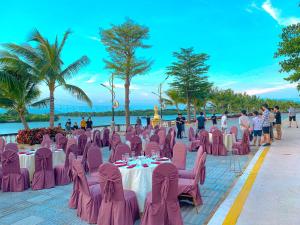 a restaurant with pink chairs and tables on the beach at Pearl Beach Hotel Quy Nhon in Quy Nhon