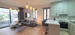 eine Küche und ein Wohnzimmer mit einem Sofa und einem Tisch in der Unterkunft Phaedrus Living: Luxury Maisonette Platres in Platres