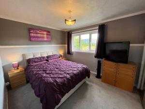 a bedroom with a bed and a flat screen tv at Spacious home near Glasgow Green in Glasgow