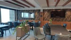 een eetkamer met tafels en stoelen en een flatscreen-tv bij President Kop - Apartman A21 in Kopaonik