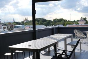 una mesa y sillas en un balcón con vistas en Issara by D Hostel, en Bangkok