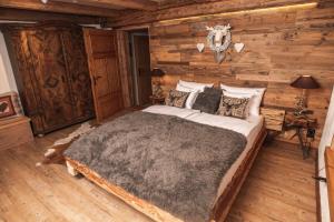 a bedroom with a bed in a log cabin at Szwajcarski Dworek in Piechowice