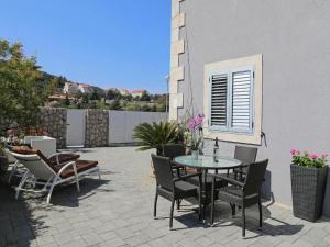 een patio met een tafel en stoelen en een gebouw bij Villa Vanda in Dubrovnik