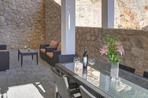 een patio met een glazen tafel en een fles wijn bij Villa Vanda in Dubrovnik