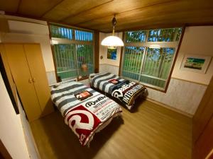 two beds sitting in a room with windows at Peakuki'i Bear's Guest House - Vacation STAY 76557v in Namihira