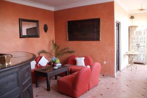 a living room with red chairs and a table at Riad Manissa in Marrakesh