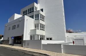 un edificio blanco al lado de una calle en Hotel Búzio, en Sines