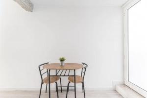 einen Tisch und Stühle in einem Zimmer mit einer weißen Wand in der Unterkunft OPO - Fantastic studio with garden in Porto
