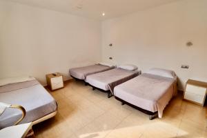 a group of three beds in a room at Hotel Ibiza in Sitges