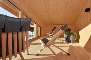duas cadeiras no alpendre de uma pequena casa em Nahturhof - Urlaub am Bauernhof natürlich erleben em Krumbach