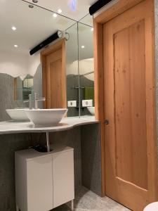 uma casa de banho com um lavatório e um espelho em SmartHome Top of the World em St. Moritz