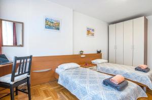 Zimmer mit 2 Betten, einem Stuhl und einem Schreibtisch in der Unterkunft Big 2-Bedroom Apt - Each Stay Triggers Donation to Non-Profit Organisation in Sofia