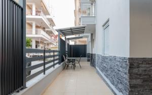 een balkon van een gebouw met een tafel en stoelen bij SithoniaRS Luxury Ground Floor Apartment With Private Garden in Neos Marmaras