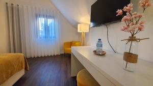 um quarto de hotel com uma cama e uma mesa com uma garrafa de água em Seasons Porto-Gaia by MyStay em Vila Nova de Gaia