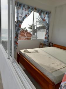 a bedroom with a bed and a view of the ocean at Hotel Remember in Hikkaduwa