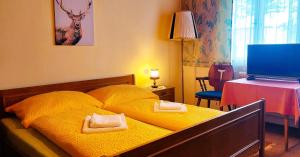 a bedroom with a yellow bed with towels on it at Gästehaus zum Gachtna in Mayrhofen