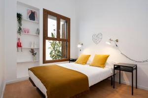 Un dormitorio con una cama con almohadas amarillas y una ventana en CASA PALACIO SUR II, en El Puerto de Santa María