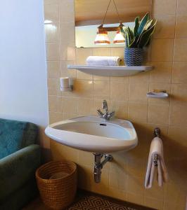 a bathroom with a white sink and a couch at Gästehaus zum Gachtna in Mayrhofen +25 photos