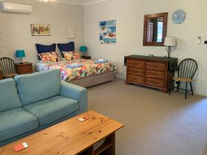 a bedroom with a bed and a couch and a table at Bentworth Lodge in Carramar