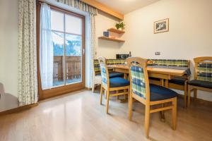 uma sala de jantar com uma mesa e cadeiras e uma janela em Niederkoflhof Durreck em Cadipietra