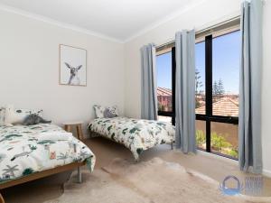 a bedroom with two beds and a large window at Summer Breeze at Avalon Beach in Wannanup
