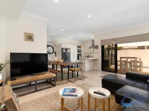 a living room with a couch and a table at Summer Breeze at Avalon Beach in Wannanup