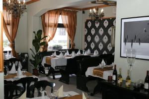 a restaurant with tables and chairs and a large window at Hotel Gloria Budapest City Center in Budapest
