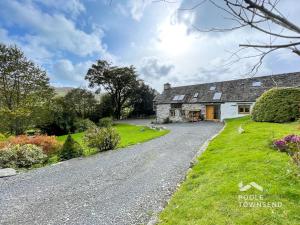 a stone cottage with a gravel road in front of it at The Low Farm and Duddon View Barn in Broughton in Furness