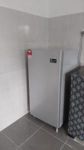 a white refrigerator in a corner of a room at Desaku Homestay in Kapar