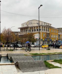 une personne faisant du vélo devant un bâtiment dans l'établissement Pilo Lala Hotel, à Lushnjë