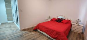 1 dormitorio con cama roja y almohadas rojas en Departamento con cochera Mar del Plata en Mar del Plata