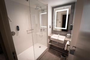 a bathroom with a shower and a sink and a mirror at Clayton Hotel Glasgow City in Glasgow
