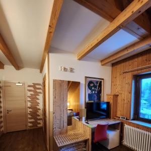 a living room with wooden walls and a large window at Hotel Tarvisio in Tarvisio